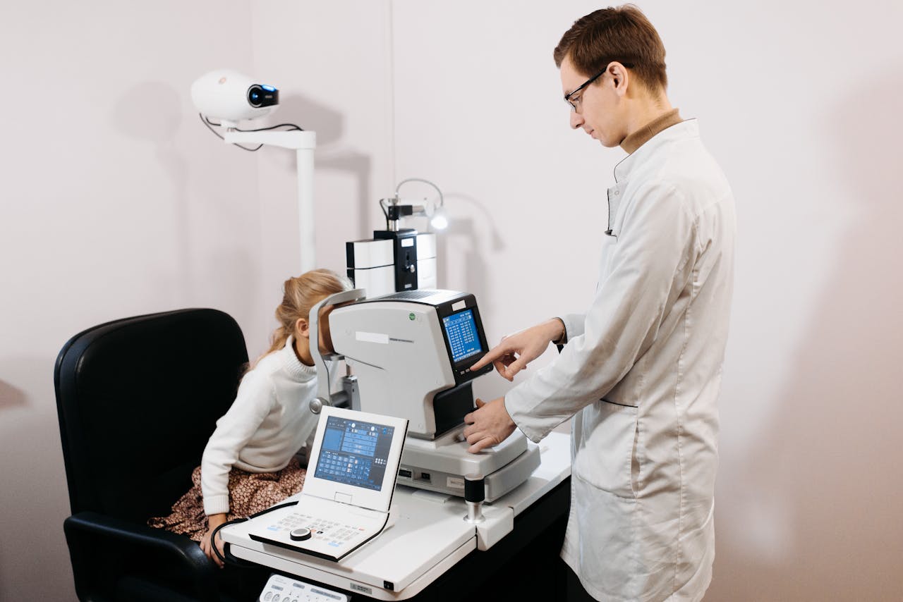 A professional optometrist examines a child's eyes using advanced equipment.